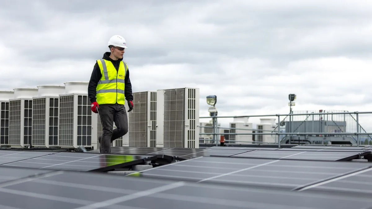 Technician inspecting rooftop solar panels in Durham, NC